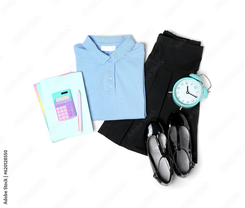 Stylish school uniform with alarm clock, pencil case and stationery isolated on white background