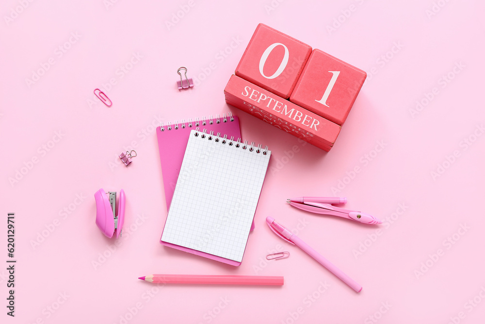 Blank notebook, stationery and calendar with date SEPTEMBER 1 on pink background