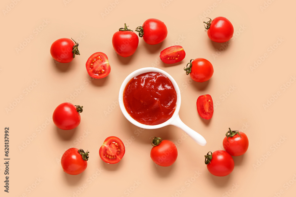 Bowl with tomato paste and fresh vegetables on orange background