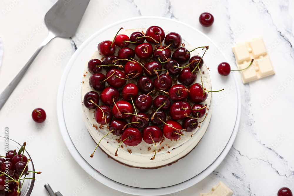 Plate with tasty cherry cake on white marble background