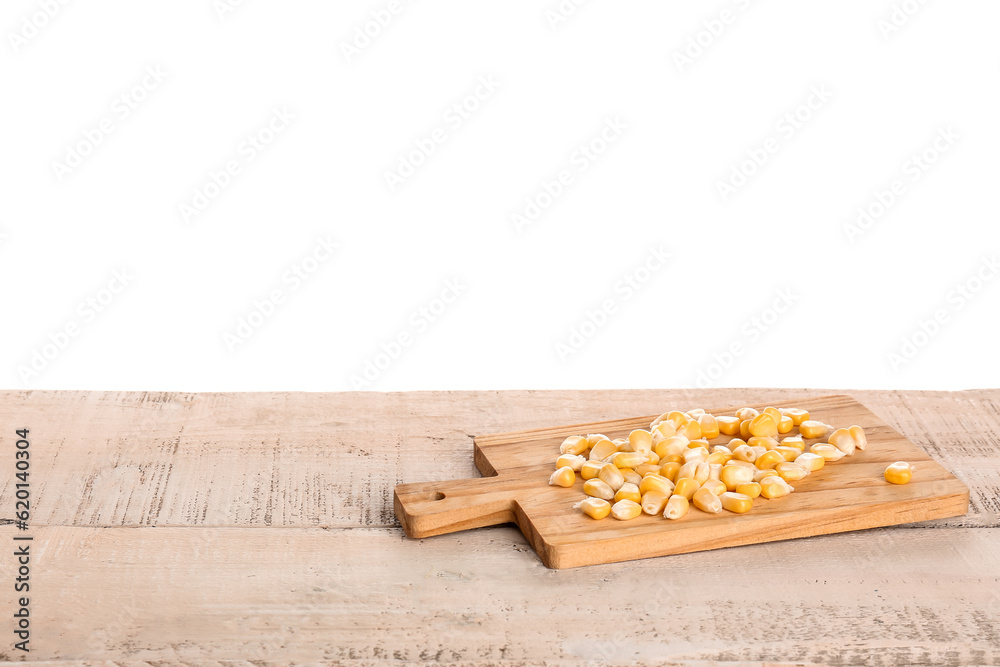 Board with fresh corn seeds on light wooden table against white background