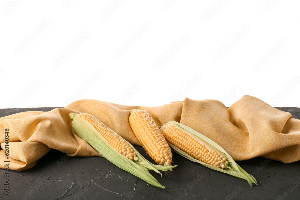 Fresh corn cobs on black table against white background