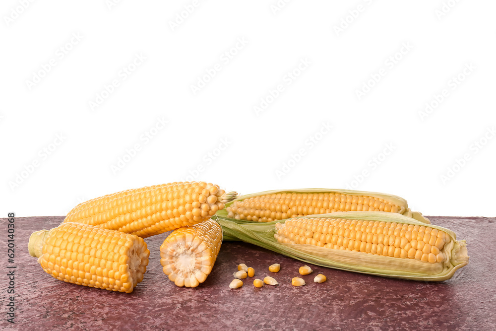 Fresh corn cobs and seeds on purple table against white background