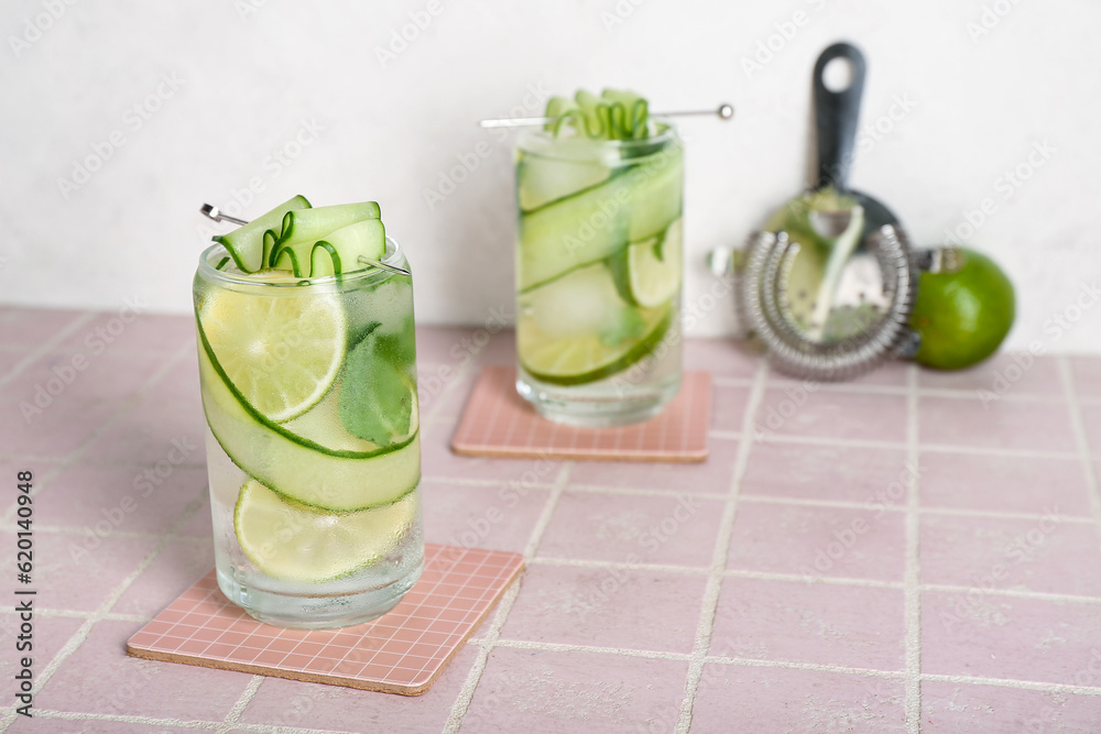 Glasses of mojito with cucumber on tile table