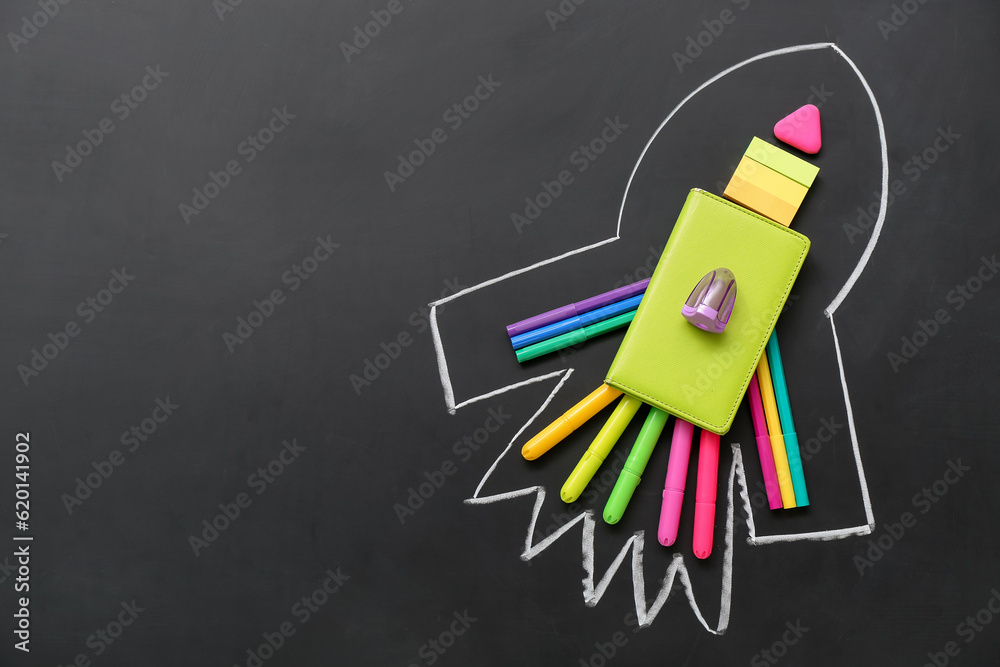 Drawn rocket with stationery on black background