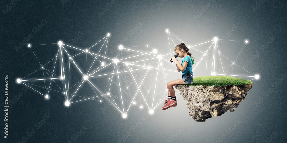 Concept of careless happy childhood with girl looking in binoculars