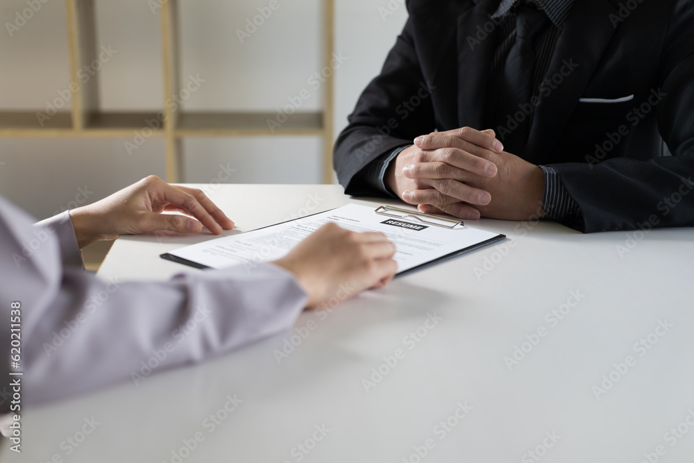 Woman submits an application to the personnel committee. The manager reads the resume and discusses 