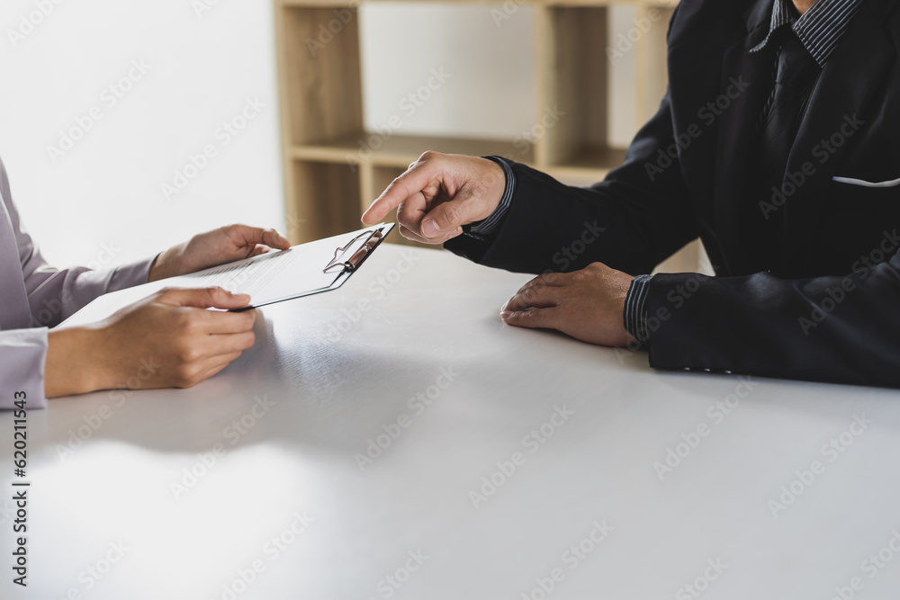 Woman submits an application to the personnel committee. The manager reads the resume and discusses 