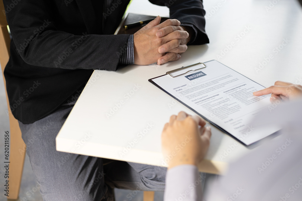 Woman submits an application to the personnel committee. The manager reads the resume and discusses 