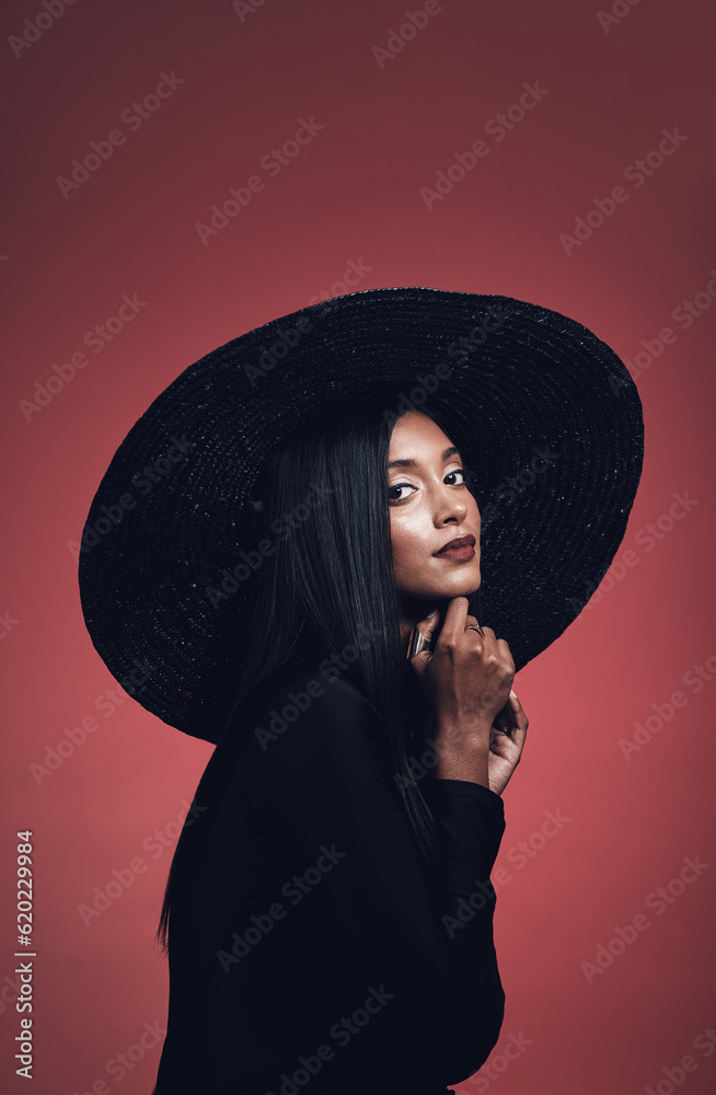 Portrait, fashion and confident woman with hat in studio isolated on red background mockup space. Fa