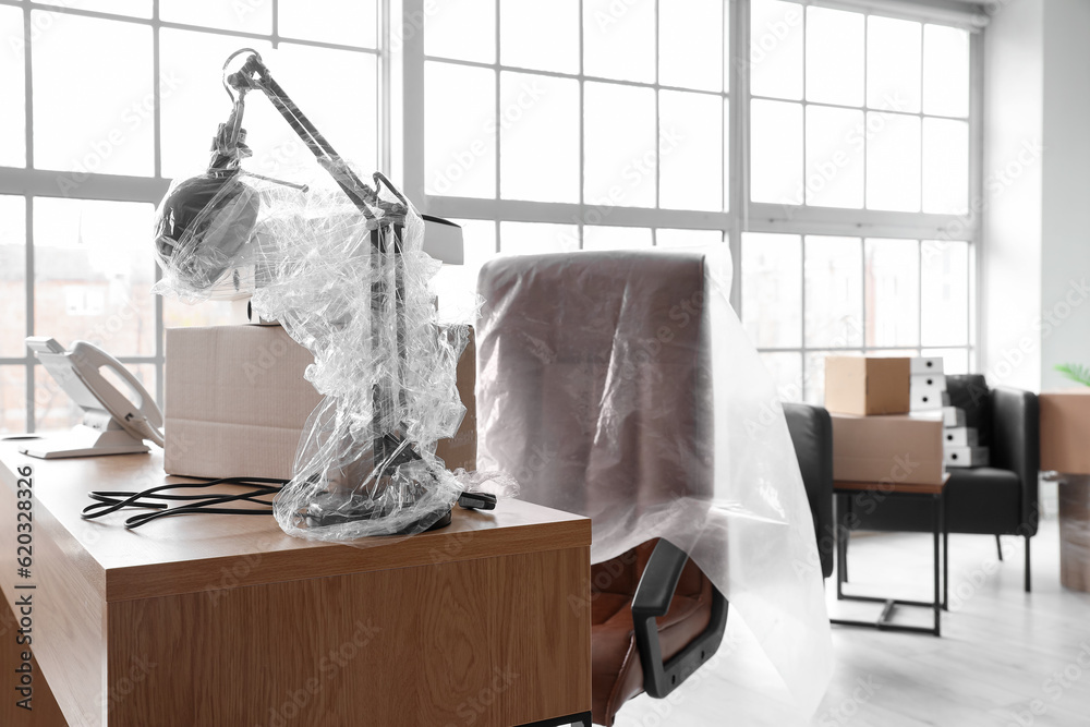 Workplace with cardboard box in office on moving day