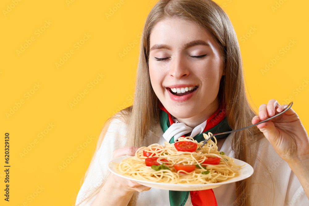 Young woman with tasty pasta on yellow background, closeup