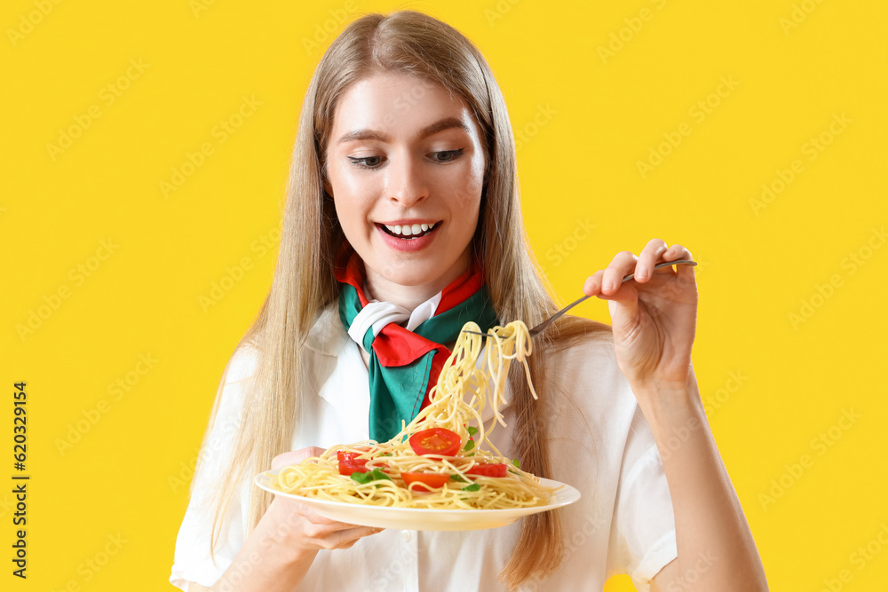 Young woman with tasty pasta on yellow background, closeup