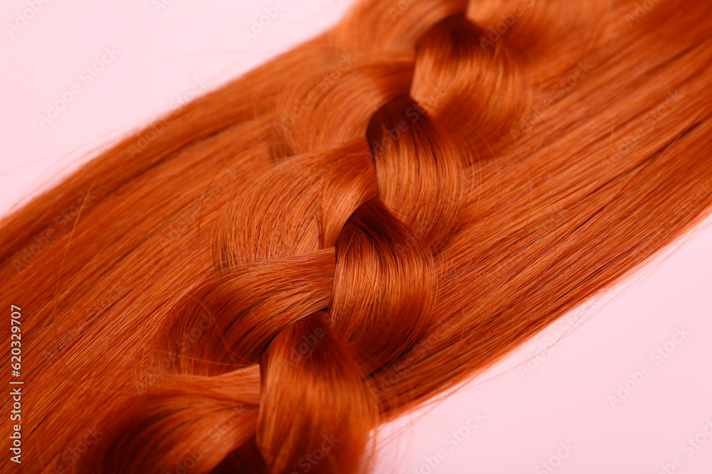 Ginger hair and braid on color background, closeup