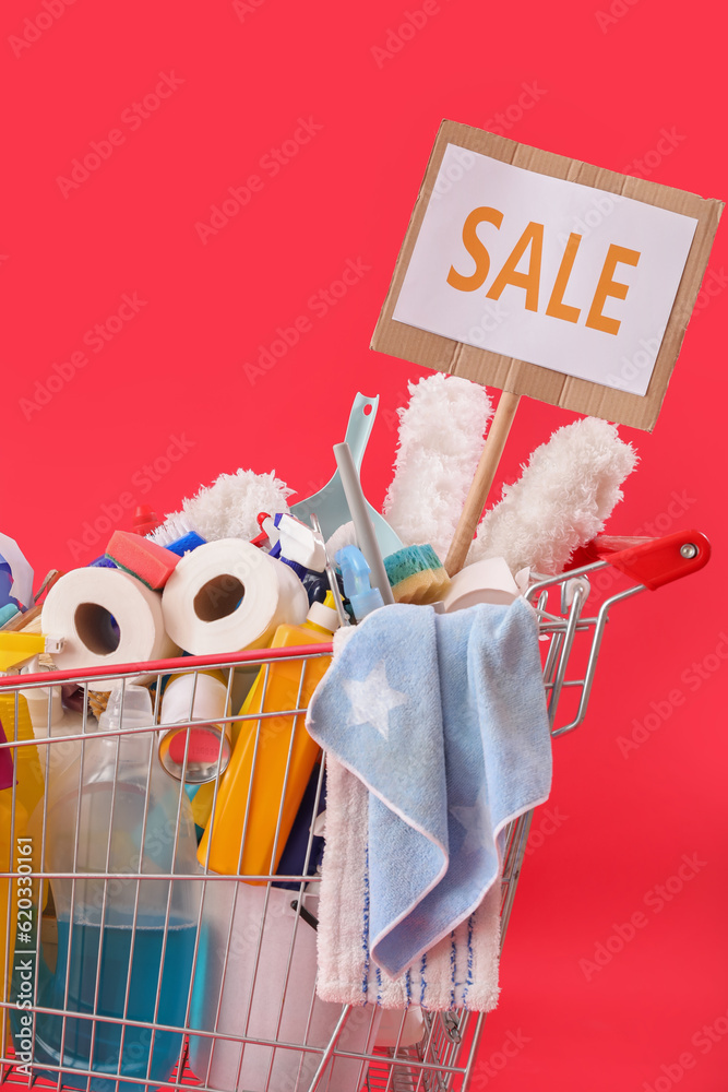 Shopping cart full of cleaning supplies with word SALE on red background