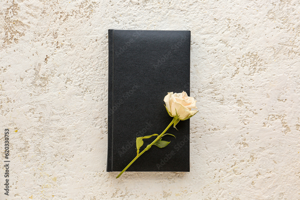 Notebook and rose flower on light background