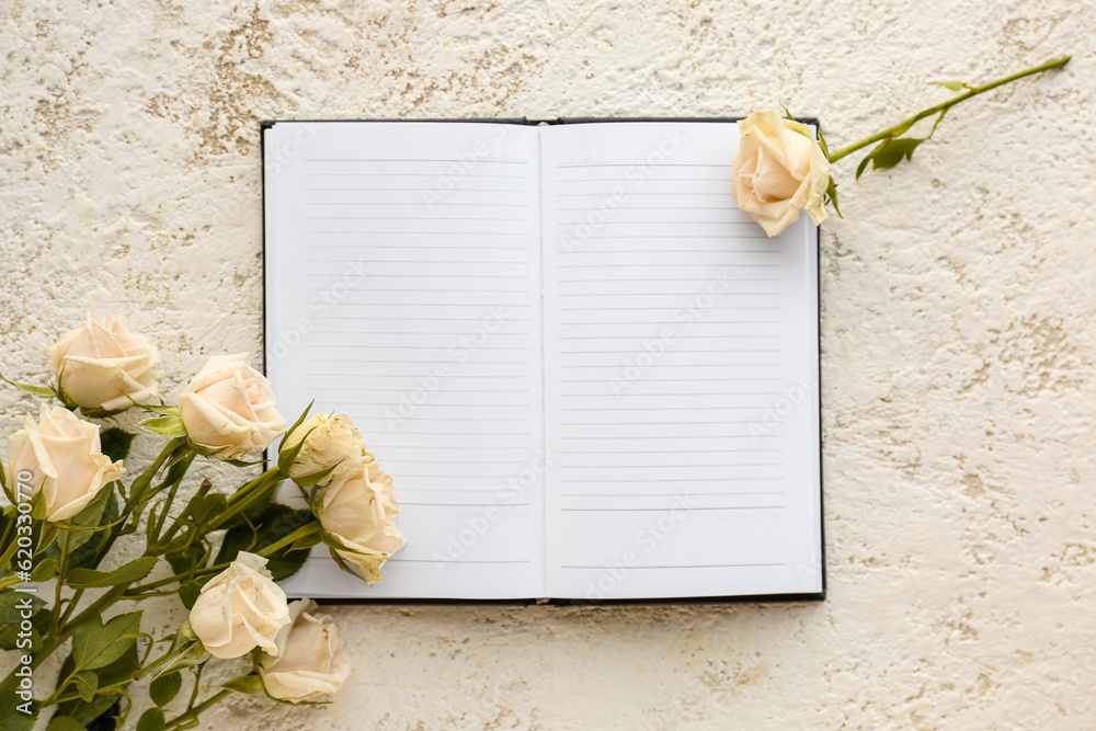 Blank open notebook and beautiful rose flowers on light background