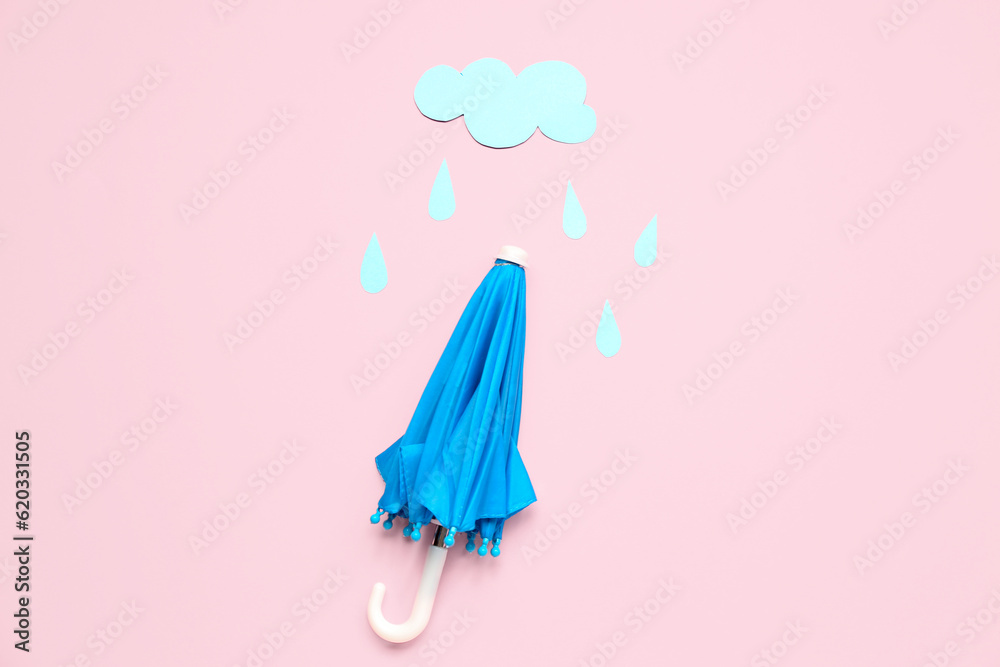 Umbrella with paper cloud and rain drops on pink background. Weather forecast concept