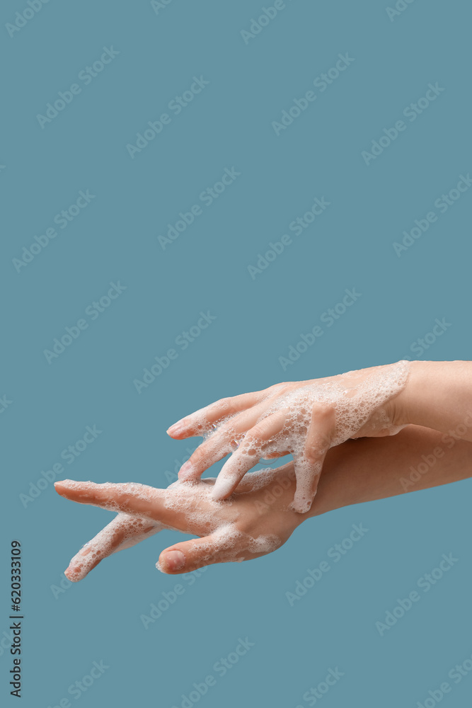 Hands in soap foam on blue background