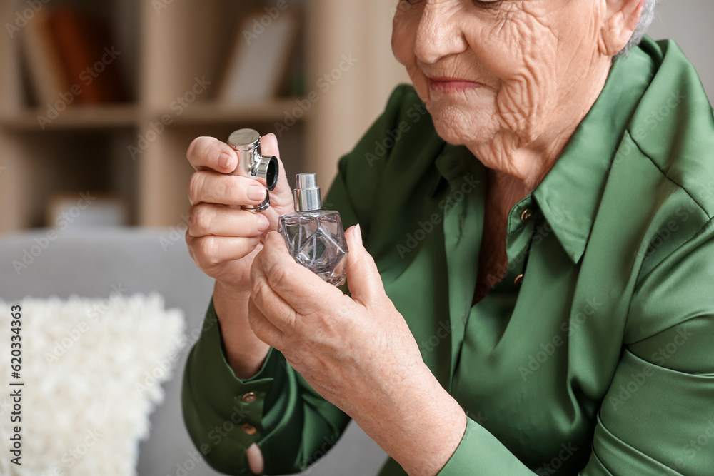 Senior woman with perfume at home, closeup