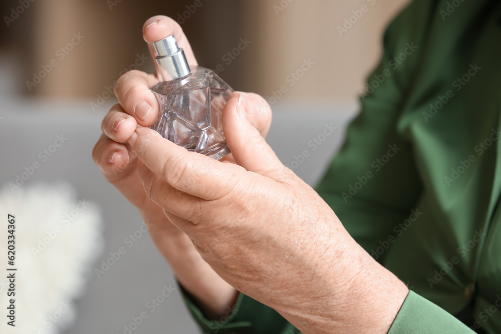 Senior woman with perfume at home, closeup