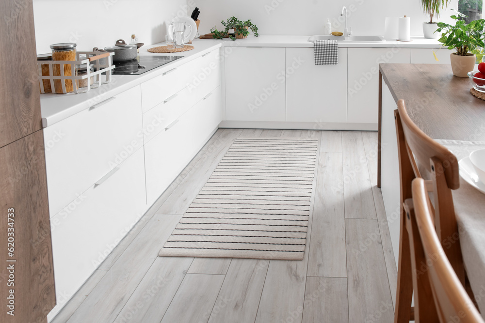 Stylish striped rug in interior of modern kitchen