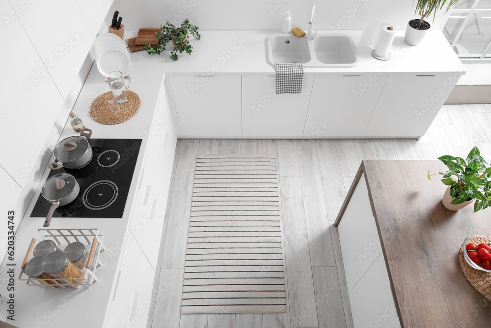 Stylish striped rug in interior of modern kitchen