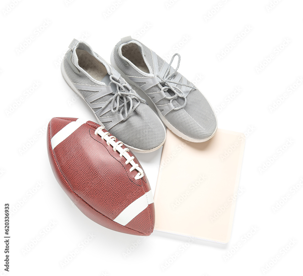 Sneakers with rugby ball and notebook isolated on white background