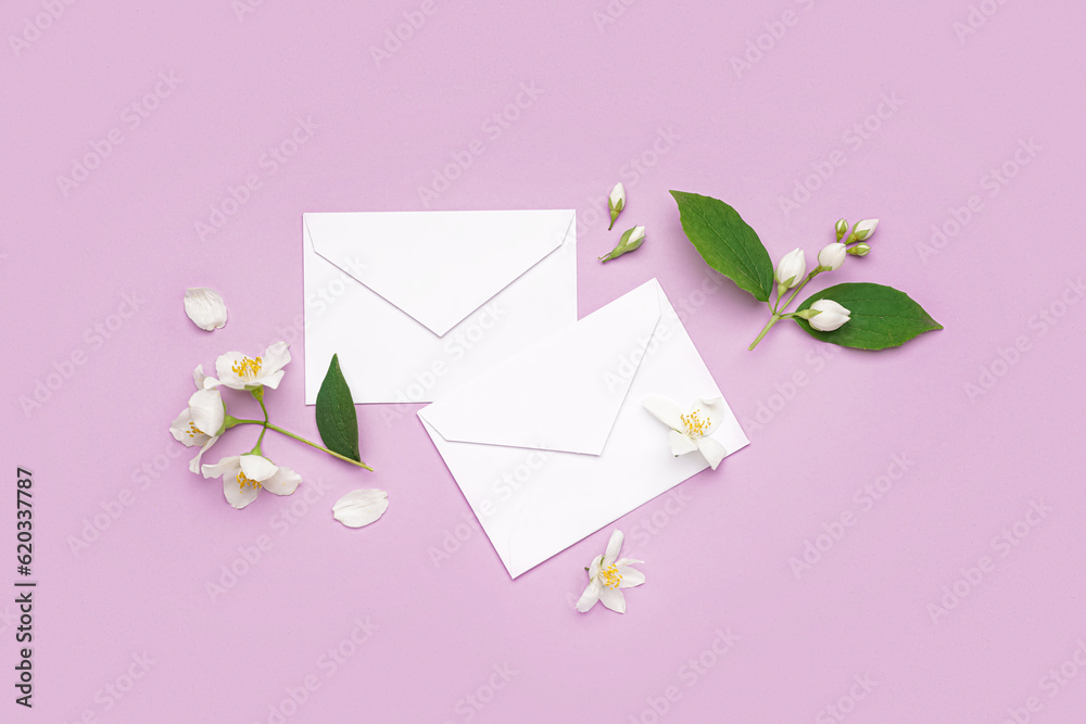 Composition with envelopes and beautiful jasmine flowers on lilac background