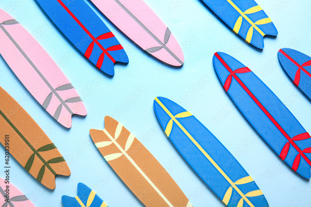 Many different colorful mini surfboards on blue background