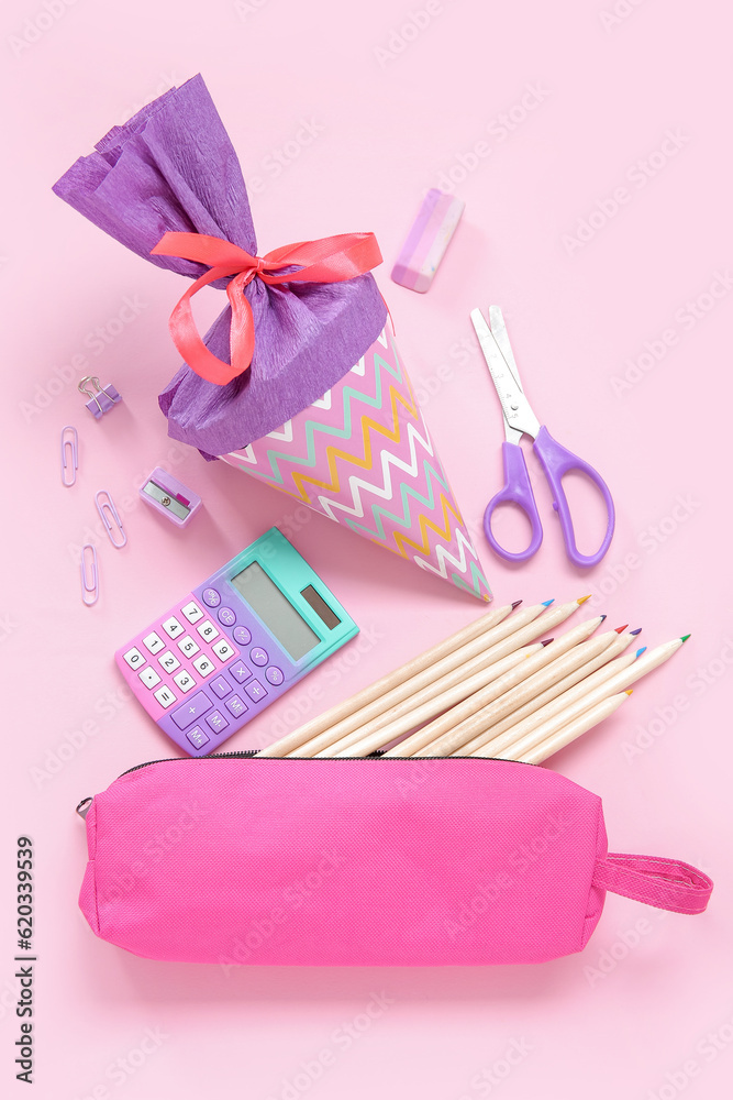 Purple school cone with different stationery on pink background