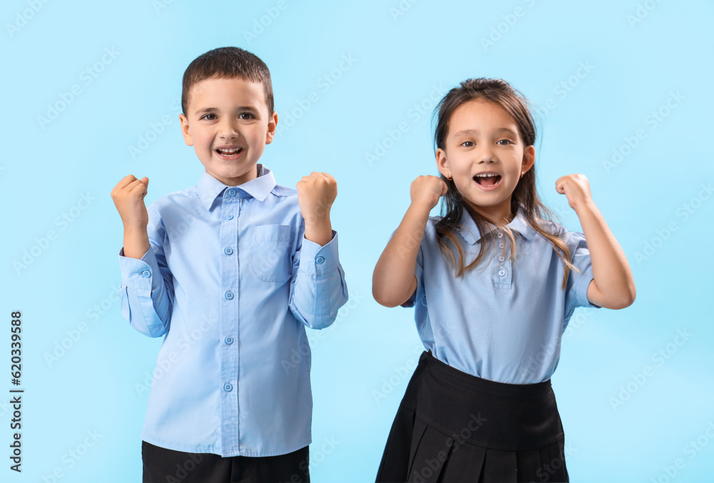 Little schoolchildren on light blue background