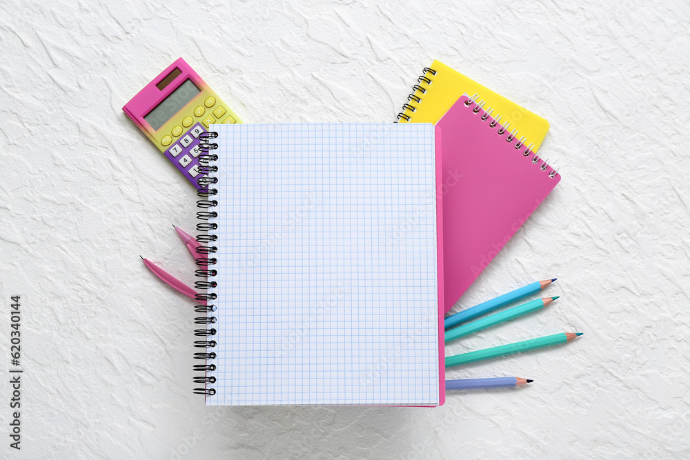 Blank notebook and different stationery on white background