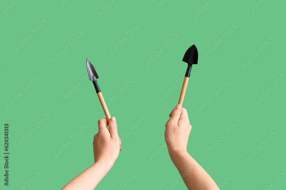 Gardener with rake and shovel on green background