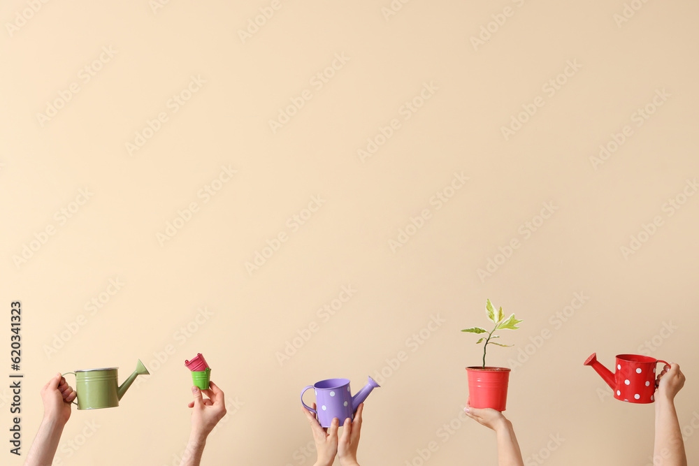 People with watering cans and plant on beige background