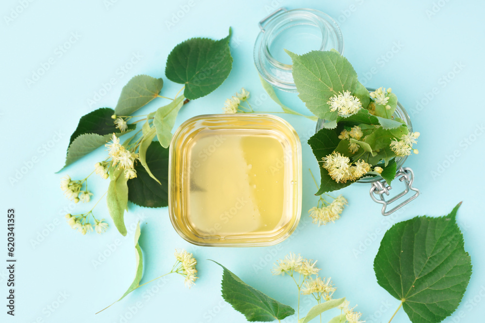 Glass bowl with linden honey on blue background