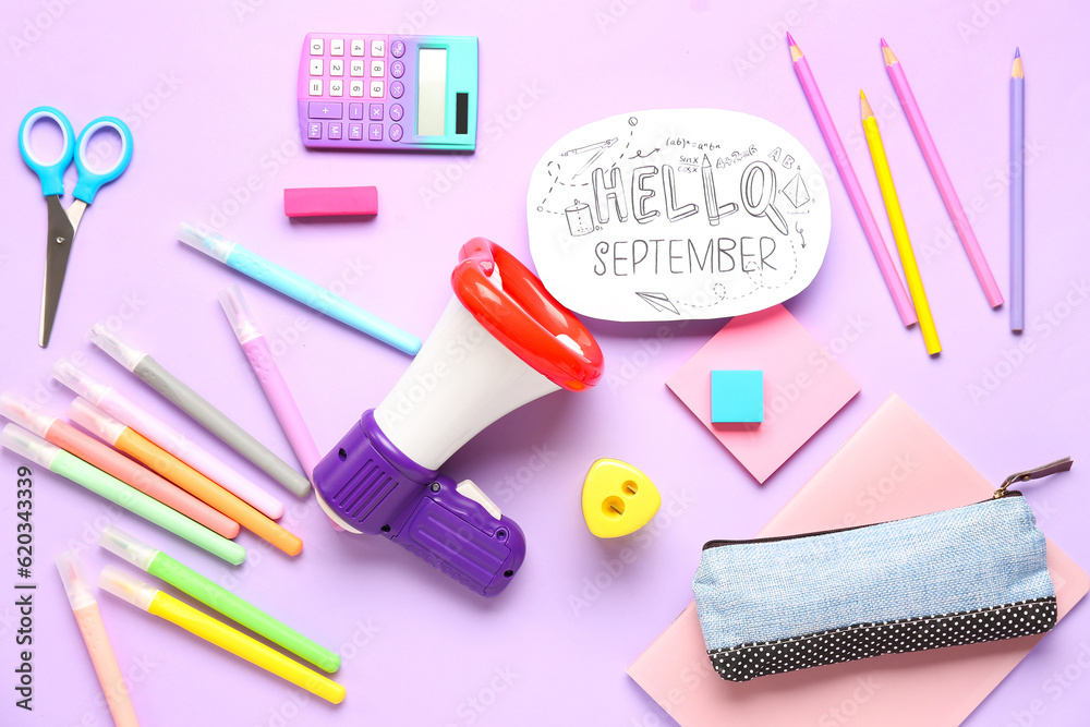 Stationery, megaphone and sheet with text HELLO SEPTEMBER on lilac background