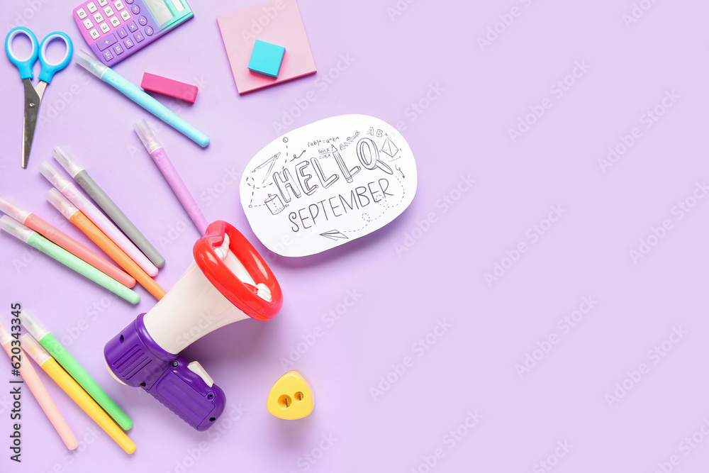 Stationery, megaphone and sheet with text HELLO SEPTEMBER on lilac background