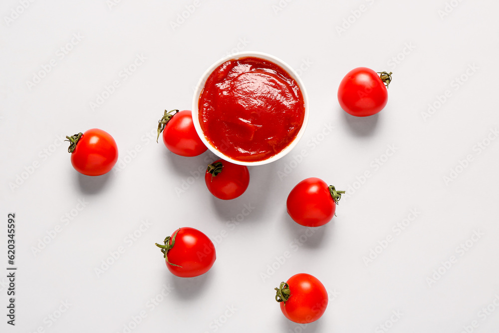 Bowl with tomato paste and fresh vegetables on white background