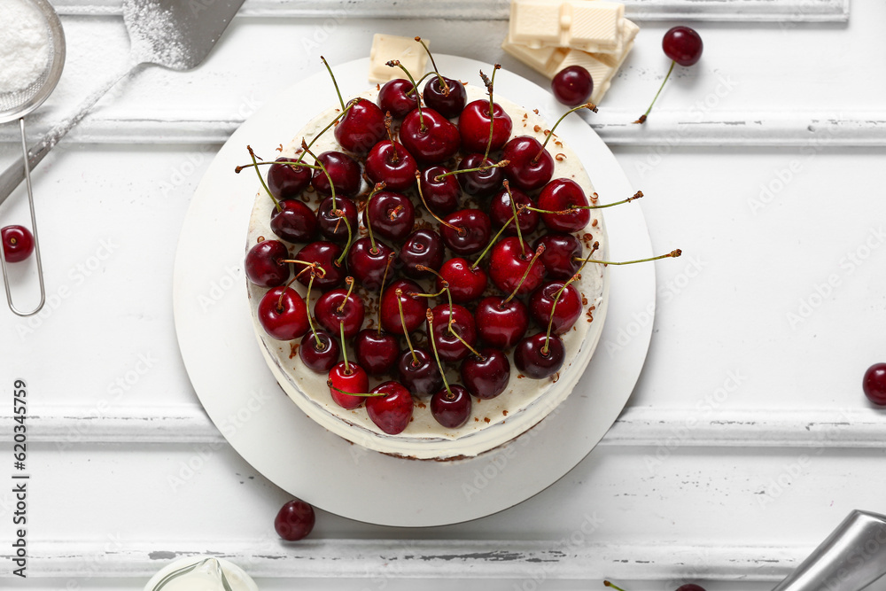 Tasty cherry cake on white wooden background