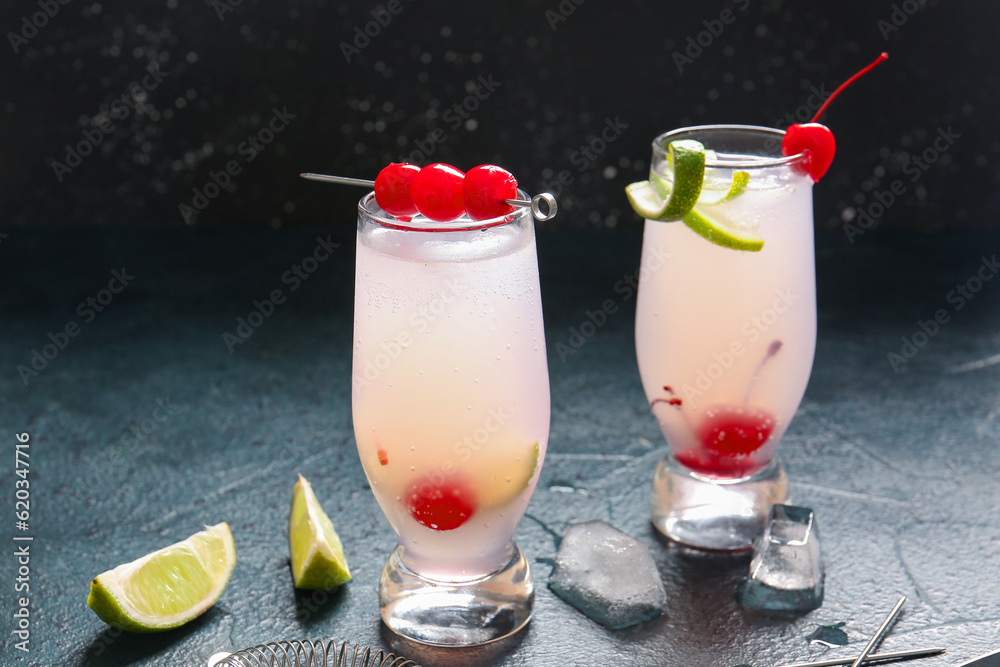 Glasses of tasty cocktail with maraschino cherries on table