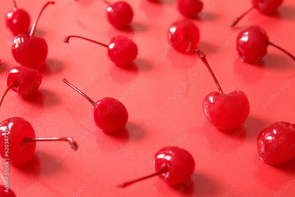 Tasty maraschino cherries on red background