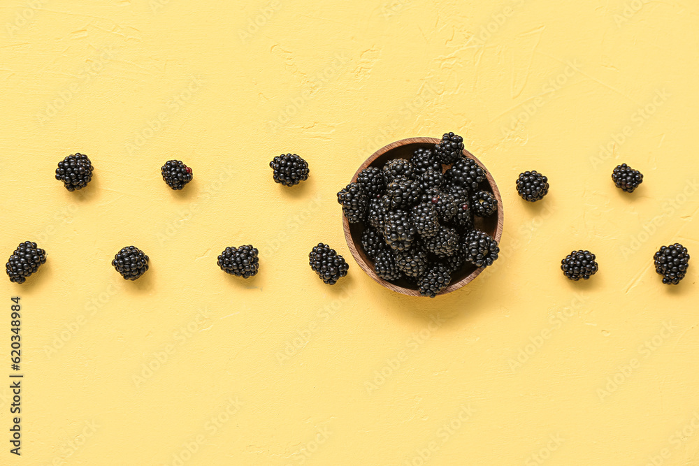 Composition with fresh blackberry on yellow background