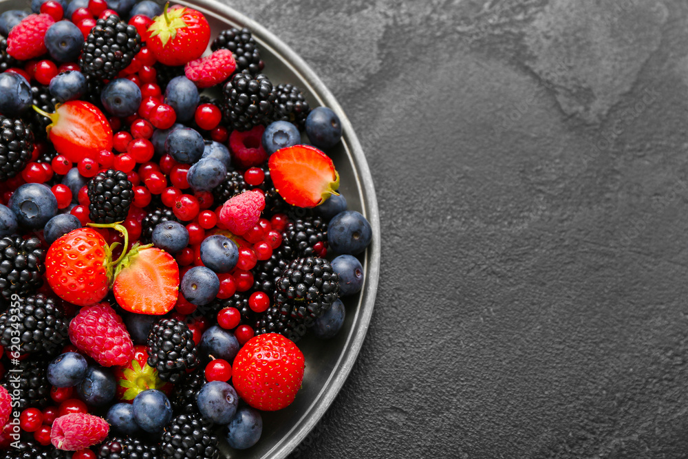 Plate with different fresh berries on grey background, closeup