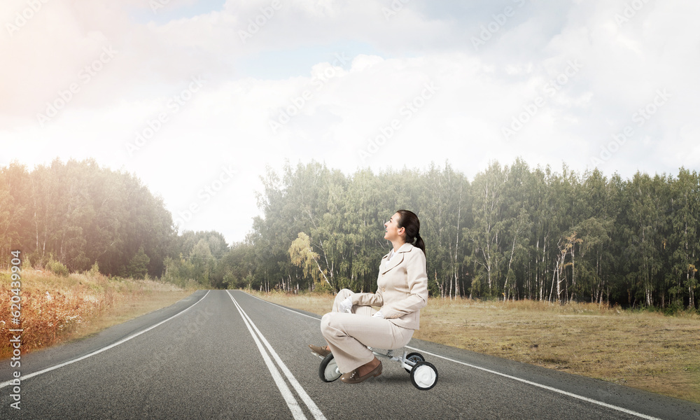 Beautiful happy woman riding childrens bicycle