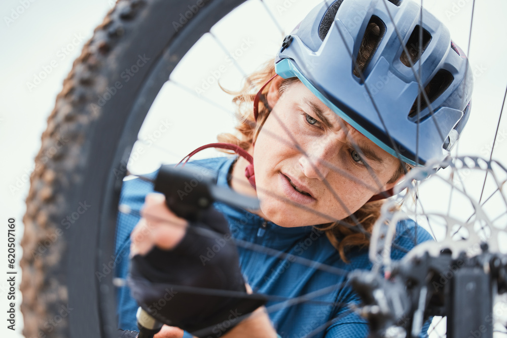 Bike repair, serious and man with a wheel in nature for a change, mechanic or travel for sports. Ser