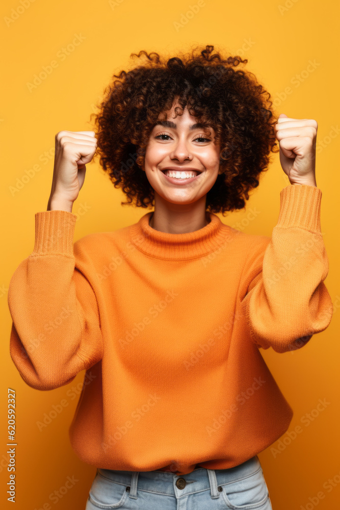 Woman in orange sweater is smiling and raising her arms in the air. Generative AI.