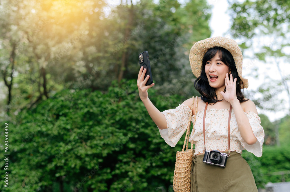 Portrait of asian young woman traveler with weaving hat, basket, mobile phone and camera on green pu