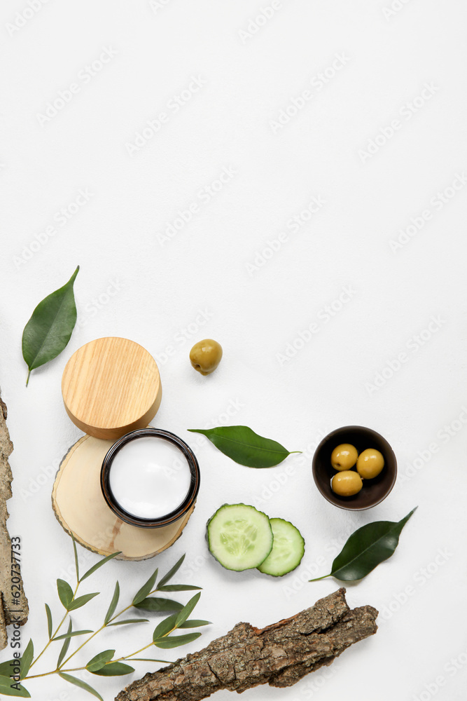 Composition with jar of cream and natural ingredients on light background