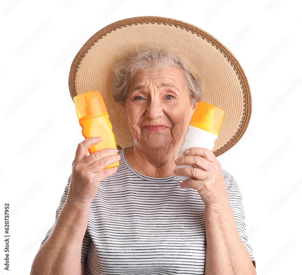 Senior woman with bottles of sunscreen cream on white background